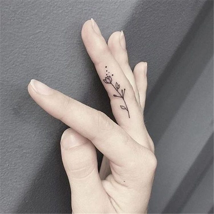 flower tattoo on middle finger, finger tattoo ideas for females 