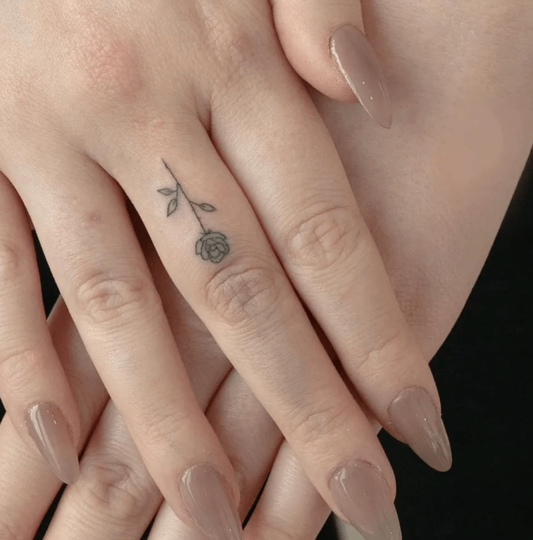 rose tattoo on middle finger for female, finger tattoo ideas for females